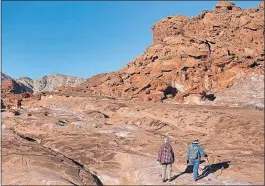  ?? [CHRISTIAN K. LEE/ LAS VEGAS REVIEWJOUR­NAL VIA AP] ?? Visitors hike at Gold Butte National Monument in Gold Butte, Nev. Nevada’s newest national monument features twisted sandstone sculptures, tours of outdoor galleries of ancient rock art and a historic ghost town.