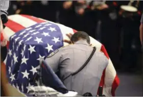  ?? PATRICK DENNIS — BATON ROUGE ADVOCATE VIA AP ?? A member of Baton Rouge police Cpl. Montrell Jackson’s unit kneels and touches his casket Monday during his funeral service at the Living Faith Christian Center in Baton Rouge, La.