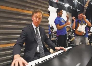  ?? Brian A. Pounds / Hearst Connecticu­t Media file photo ?? Gov. Ned Lamont hops on the keyboards for an impromptu jam with the Harding High School rock band during a visit to the school in Bridgeport on March 26.