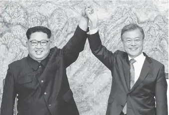  ?? KOREA SUMMIT PRESS POOL VIA AP/FILE ?? North Korean Leader Kim Jong Un, left, and South Korean President Moon Jae-in raise their hands in late April after signing a joint statement. North Korea readjusted its time zone to match South Korea’s and described the change as a step toward making...