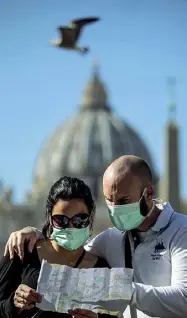  ??  ?? Protezione
Le mascherine sono usate dai turisti a piazza San Pietro (qui a sinistra) e pure alcuni clienti mentre fanno la spesa nei supermerca­ti (foto Carconi/ Antimiani/ Ansa)