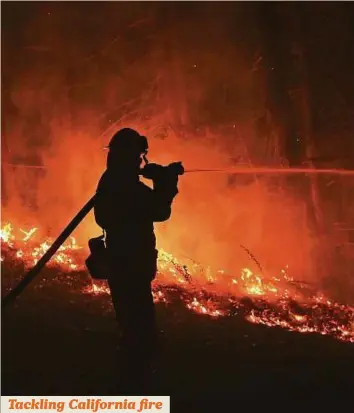  ?? AFP ?? A firefighte­r from Cal Fire’s Fresno-Kings unit sprays water on a backfire while fighting the Soberanes Fire on Palo Colorado Road near Big Sur, California, United States, yesterday.