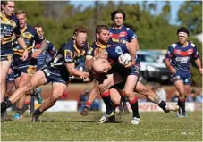  ??  ?? Nick Bainbridge (right) tries to wrestle Warwick captain Michael Bloomfield to the ground.