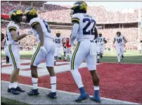  ?? JAY LAPRETE — THE ASSOCIATED PRESS ?? Michigan’s Cornelius Johnson, center, celebrates with teammates after his touchdown against Ohio State during the first half on Saturday in Columbus, Ohio.