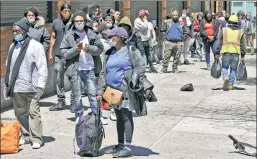  ?? ?? Opening the floodgates: Hundreds lined up in Brooklyn to apply for food stamps in May 2020, soon after the pandemic’s start.