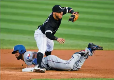  ?? Associated Press ?? Texas Rangers' Elvis Andrus steals second base as Chicago White Sox second baseman Yolmer Sanchez stands above him during the first inning of a baseball game Friday in Chicago.