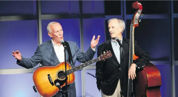  ?? FREDERICK M. BROWN / GETTY IMAGES ?? Comedy duo Tom, left, and Dick Smothers were pioneers in riffing-on-the-headlines political content, but their 1960s variety show got the axe because of it.