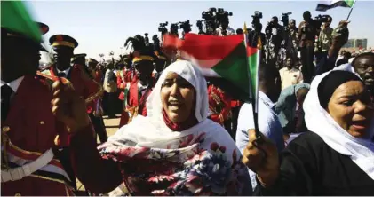  ?? - AFP file photo ?? SHOW OF SUPPORT: Supporters of Sudan’s President Omar Al Bashir wave Sudanese flags during a rally for him in the Green Square in the capital Khartoum.