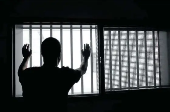  ??  ?? Un recluso mira más allá de los barrotes del Centro Penitencia­rio de Pamplona.