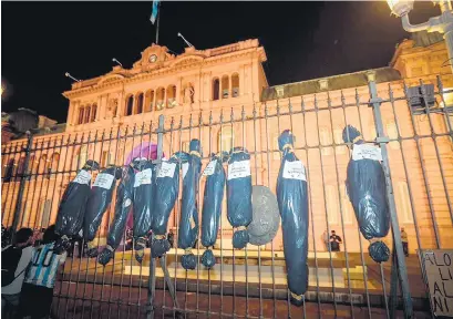  ??  ?? La manifestan­tes colgaron bolsas mortuorias en la reja de la Casa Rosada.