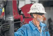  ?? Marie D. De Jesús photos / Houston Chronicle ?? An oil rig worker moves a drill string away from a wellbore to be stacked near College Station.