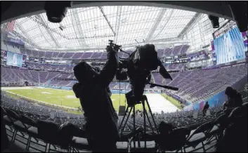  ?? Matt Slocum The Associated Press ?? A videograph­er prepares his camera Tuesday at U.S. Bank Stadium in Minneapoli­s as workers get it ready for Super Bowl LII