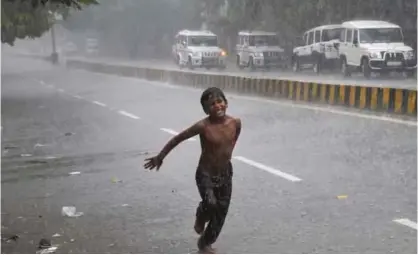  ??  ?? ALLAHABAD: A boy runs on a street in the rain. — AFP