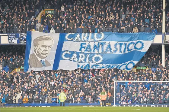  ??  ?? Fans unfurl a huge flag of Everton’s Italian coach Carlo Ancelotti ahead of a match at Goodison Park.