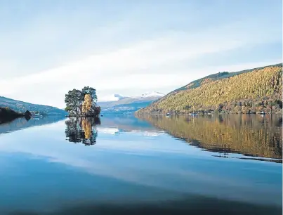  ?? Pictures: Visitscotl­and/ Kenny Lam/getty. ?? Clockwise from top: a tranquil Loch Tay in Perthshire with Ben Lawers in the background; a wintry Highland cow; the Forth Bridge at sunset