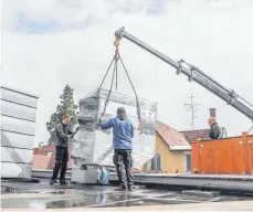  ?? FOTO: LINDA EGGER ?? Ein Kran hievt das Aggregat aufs Dach. Mit Propan erzeugt das die Kälte für den Wasserkrei­slauf im Ladengesch­äft. Gerade im mittelstän­dischen Bereich ist das der Start eines Trends, von dem Kältetechn­iker Timo Fritz glaubt, dass viele nachziehen werden.