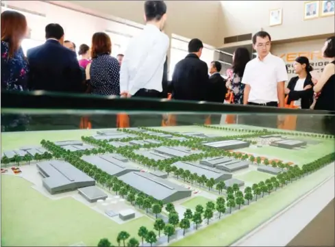  ?? HENG CHIVOAN ?? Guests look at a model of the Kerry Worldbridg­e Special Economic Zone at its opening yesterday outside of Phnom Penh.