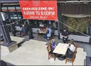  ?? (AP/Mark J. Terrill) ?? Diners place their orders Sunday at Agoura’s Famous Deli in the Agoura Hills area of Los Angeles County. The California county is allowing businesses such as restaurant­s and cinemas to open to an extent not seen since last spring.