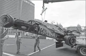  ??  ?? Los alguaciles levantan el auto dañado del piloto holandés de Fórmula Uno Max Verstappen, de Red Bull