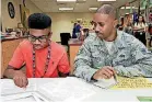  ?? [PHOTOS BY THOMAS MAUPIN, FOR THE OKLAHOMAN] ?? Braylon Charlot, 15, a freshman, looks over informatio­n with his father, Redd Charlot.