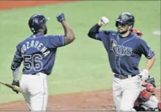  ?? Steve Nesius / Associated Press ?? Tampa Bay’s Randy Arozarena, left, greets Brandon Lowe after Lowe’s solo home run Saturday against Boston.