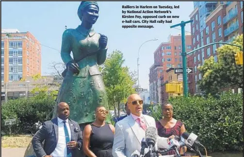  ??  ?? Ralliers in Harlem on Tuesday, led by National Action Network’s Kirsten Foy, opposed curb on new e-hail cars. City Hall rally had opposite message.