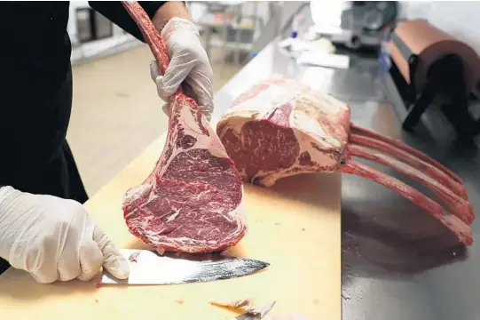  ?? CARLINEJEA­N/SUN SENTINEL ?? Jeff Sternshein, executive chef at A Cut Above Butcher & Provisions in Fort Lauderdale, cuts a tomahawk steak Jan. 6 for a customer.