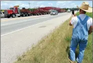  ?? NWA Democrat-Gazette/ANDY SHUPE ?? Harlan Shedell of Highfill takes a photograph Thursday of a transforme­r being moved for Southweste­rn Electric Power Co. while stopped to add equipment on U.S. 62 east of Prairie Grove. The device, trailer and three trucks used to move it weigh a...