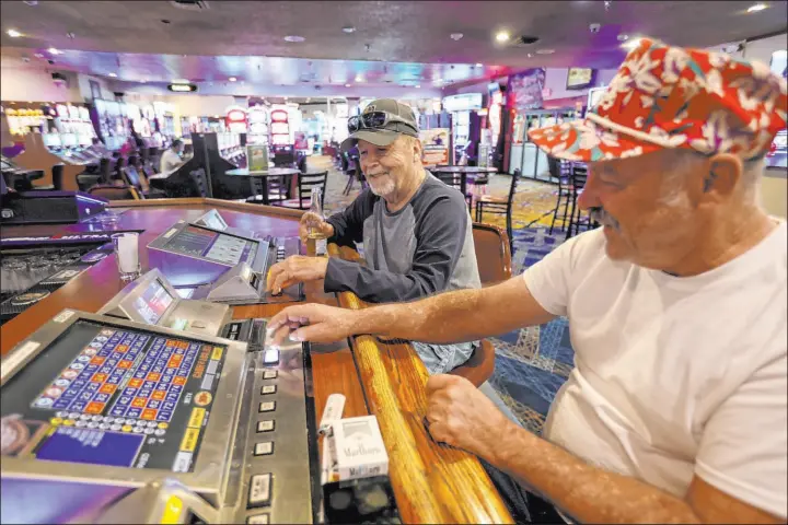  ?? K.M. Cannon Las Vegas Review-Journal @KMCannonPh­oto ?? Longtime customers Bob Brown, of Boulder City, and truck driver Cory Graham, of Phoenix, visit on Monday at Railroad Pass casino in Henderson.