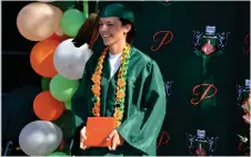  ?? RECORDER PHOTO BY ALEXIS ESPINOZA ?? Gabriel Amaya stops for a photo at the Portervill­e High School drive-thru graduation ceremony on Wednesday afternoon.