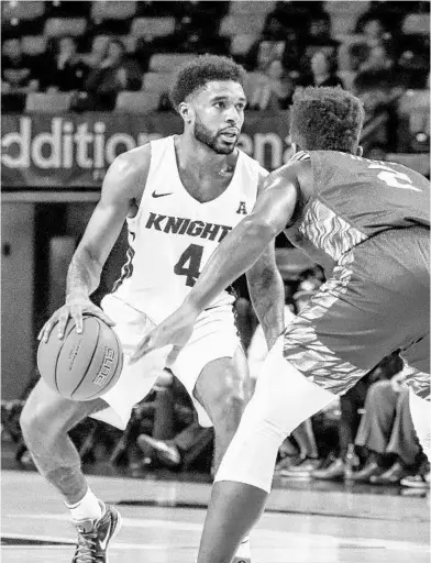  ?? UCF ATHLETICS ?? UCF guard Ceasar DeJesus controls the ball during the Knights’ win over Green Bay on Tuesday night at Addition Financial Arena.