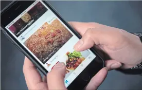  ?? GRAEME ROY
THE CANADIAN PRESS ?? A woman uses the Kouzina app on her smartphone. Apps that allow home chefs to sell dishes prepared in their own kitchens are increasing­ly popping up.