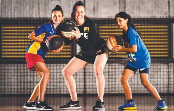  ?? Picture: ALIX SWEENEY ?? FUN TIMES: Fire's Tess Madgen (centre) with Ella Rose, 11, and Samantha Davila, 11, at Townsville Basketball Stadium yesterday.