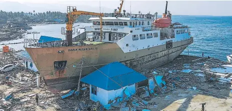  ?? Afp ?? DESASTRE. La fuerza del tsumani movió esta embarcació­n que quedó entre dos viviendas. La instalació­n portuaria está destruida.