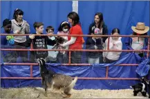  ?? ?? Grade 3 students from All Saints Catholic School visit the Little Bitty Ranch at Discover the Farm, April 28. Jackie Wiebe (centre) is holding a baby goat for them to pet.