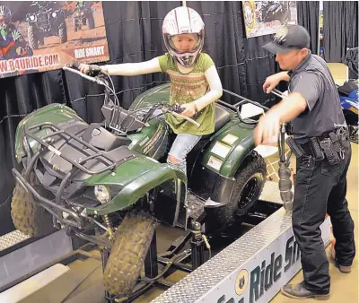  ?? PHOTO COURTESY OF N.M. GAME AND FISH ?? A young participan­t in last year’s New Mexico Department of Game and Fish’s hunting and fishing show tries out ATV safety gear.