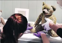  ?? CHARLES KRUPA/THE ASSOCIATED PRESS ?? Gallery stylists position antique Winnie the Pooh bears while preparing the Winnie-the-Pooh: Exploring a Classic exhibit at the Museum of Fine Arts in Boston.