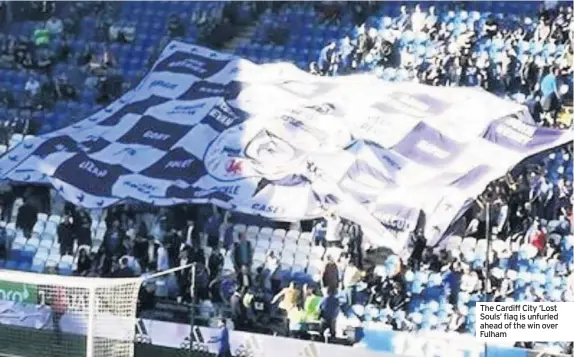  ??  ?? The Cardiff City ‘Lost Souls’ flag is unfurled ahead of the win over Fulham