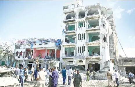  ?? (AP FOTO) ?? ATTACK. Security forces examine the scene after a bomb attack on Ambassador Hotel in Mogadishu, Somalia. Somalia’s Islamic extremist rebels, al-Shabab, stormed the hotel, often frequented by government officials and business executives.