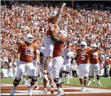  ?? JEFFREY MCWHORTER — THE ASSOCIATED PRESS ?? Texas tight end Jared Wiley (18) is lifted up by Texas offensive lineman Christian Jones (70) after making a touchdown catch during the first half ofSaturday’s game against Oklahoma at the Cotton Bowl in Dallas.