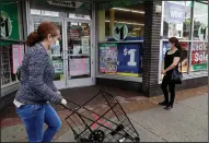  ?? (AP) ?? A woman walks by a Dollar Tree store last year, while another waits in line to shop in the store, which was limiting customers in Chicago. Discount chain Family Dollar and its parent, Dollar Tree, arbitrated 1,135 cases filed by employees in 2020 — nearly a third of all U.S. cases that year.