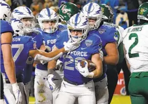  ?? LM OTERO AP ?? Air Force back Brad Roberts (20) is congratula­ted after scoring a touchdown against Baylor in the first half. He had two TDs on the night in the Falcons’ victory.