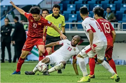  ??  ?? Jordan’s Khalil and Vietnam’s Cong Hoang in action during their match at Al Maktoum stadium in Dubai. —
