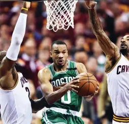  ?? (Reuters) ?? BOSTON CELTICS guard Avery Bradley drives to the basket between Cleveland Cavaliers defenders LeBron James (left) and J.R. Smith during the second half of Sunday night’s Game 3 of the teams’ Eastern Conference Finals in Cleveland. Bradley scored 20...