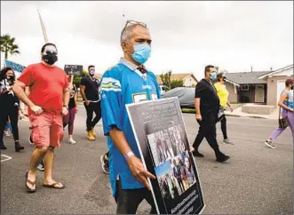  ?? U-T ?? Anthony Carolino, center, walks in an anti-police brutality rally in Encanto on Oct. 24. His brother, Dennis Carolino, was fatally shot in August 2019 when he rushed toward police while holding a shovel.
