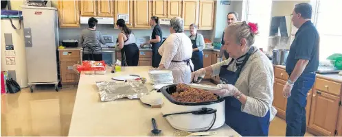  ?? ERIC BOURQUE ?? Volunteers at work in the kitchen at Yarmouth Wesleyan Church on Jan. 30. That day’s spaghetti lunch was part of the 100 Meals program.