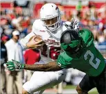  ?? ALLEN EYESTONE / THE PALM BEACH POST ?? FAU’s Jason Driskel (left) stiff-arms a North Texas defender near the goal line in Saturday’s C-USA title game win.