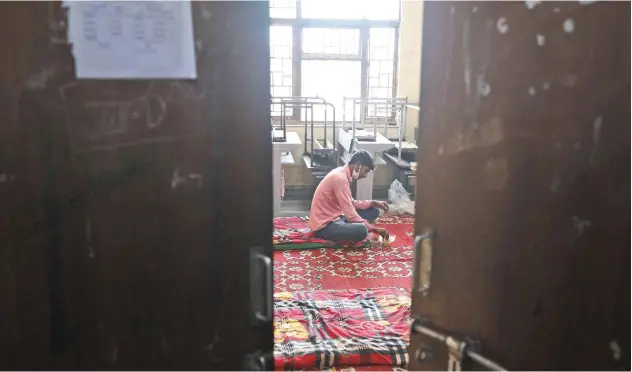  ?? Associated Press ?? ↑
A migrant labourer eats a meal at a government school in New Delhi on Tuesday.