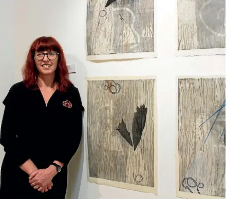 ??  ?? Michaela Stoneman beside her Wai Wairua Series prints in her exhibition ‘The Nun and the Poet: Jerusalem’.