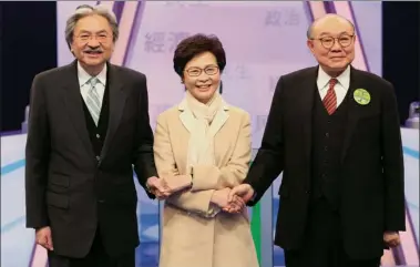  ?? PROVIDED TO CHINA DAILY ?? Chief Executive candidates Carrie Lam Cheng Yuet-ngor (center), John Tsang Chun-wah (left) and Woo Kwok-hing shake hands before a debate organized by seven electronic media outlets in Hong Kong on Tuesday.